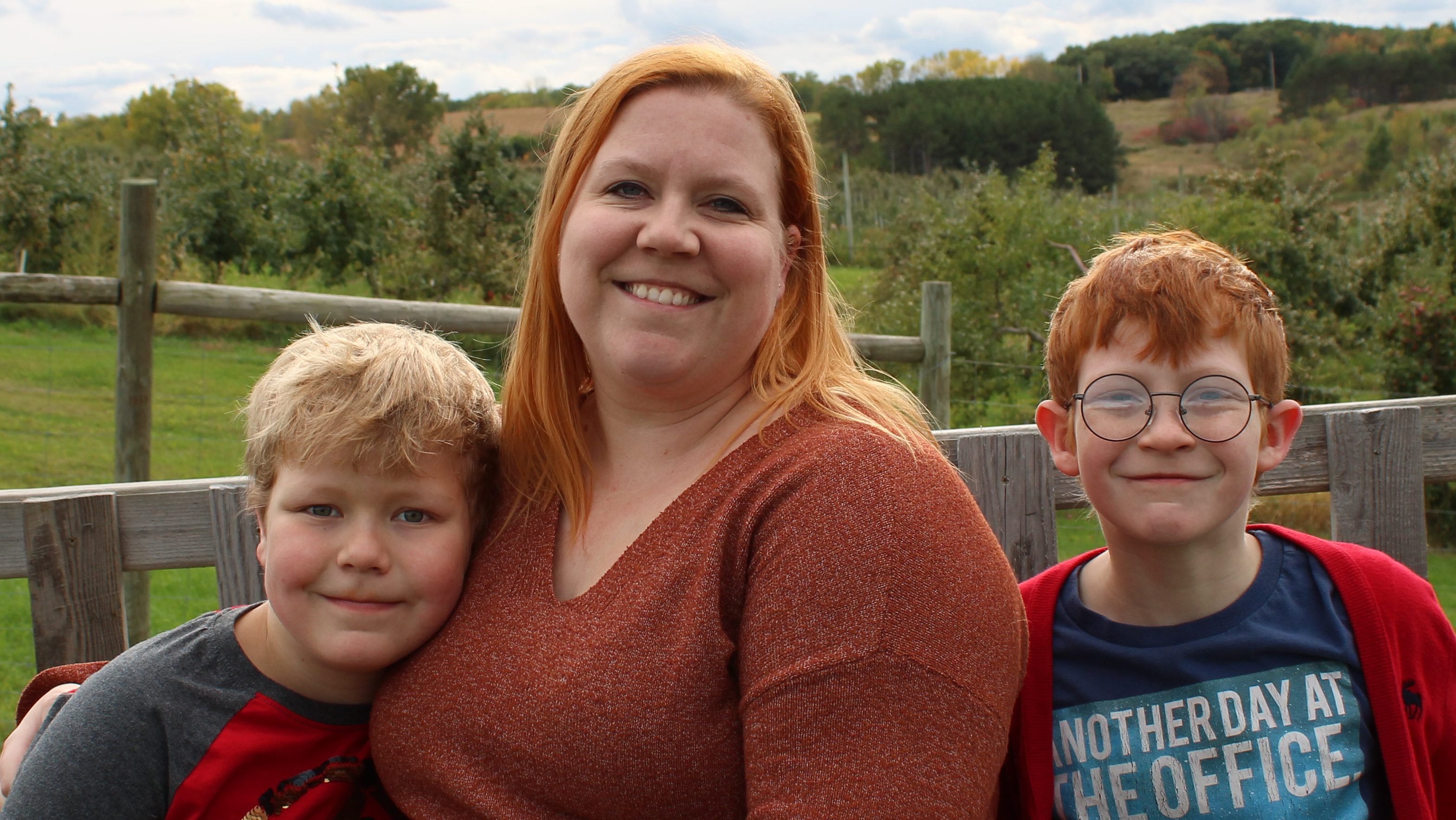 Image of Meg and her two sons at a local apple orchard. 